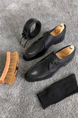 Elegant black leather single monk strap loafers with sleek design, buckle closure, and timeless style.