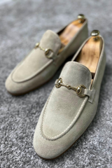 Stylish beige suede loafers with gold bit accents, perfect for classy and sophisticated occasions.