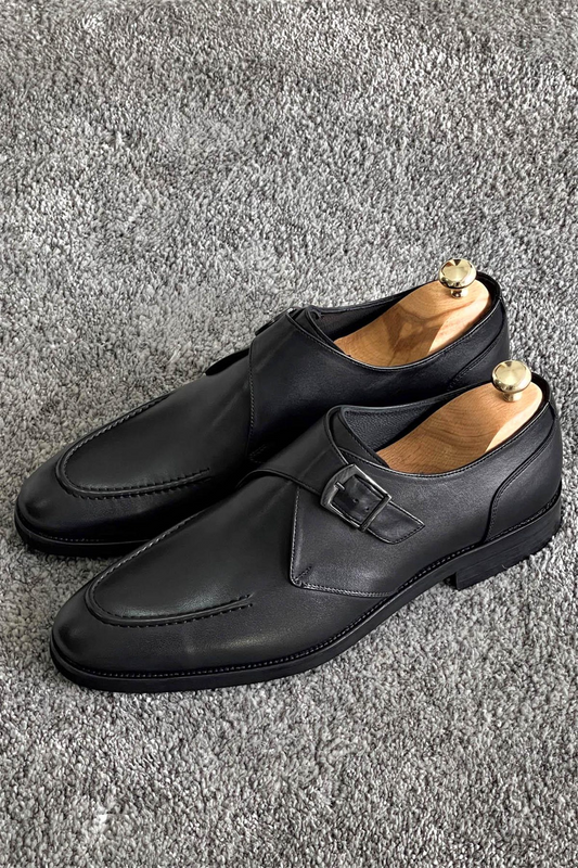 Elegant black leather single monk strap loafers with sleek design, buckle closure, and timeless style.